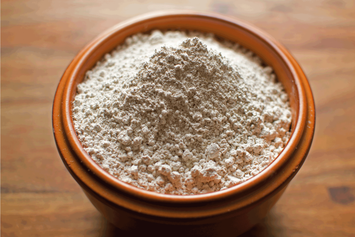 Diatomaceous Earth in an earthenware bowl against a wooden background