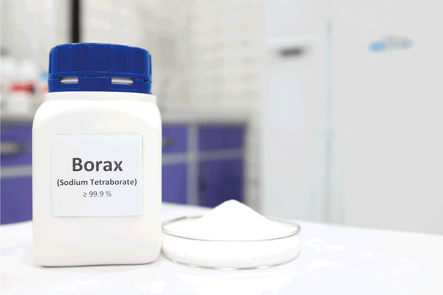 Selective focus of a bottle of borax chemical compound or sodium tetraborate beside a petri dish with solid powder substance.