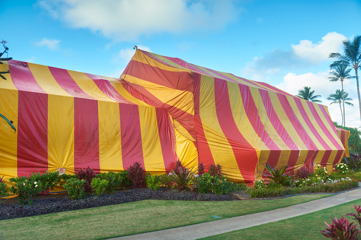 A huge striped tent covering a hotel in Hawaii. The tent is used to fumigate a building to remove termites.