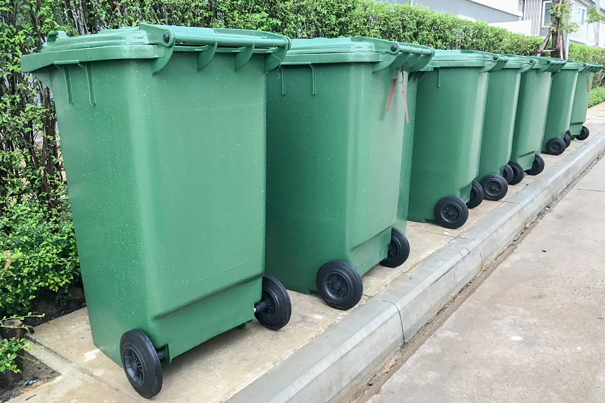 A line up of green garbage bins