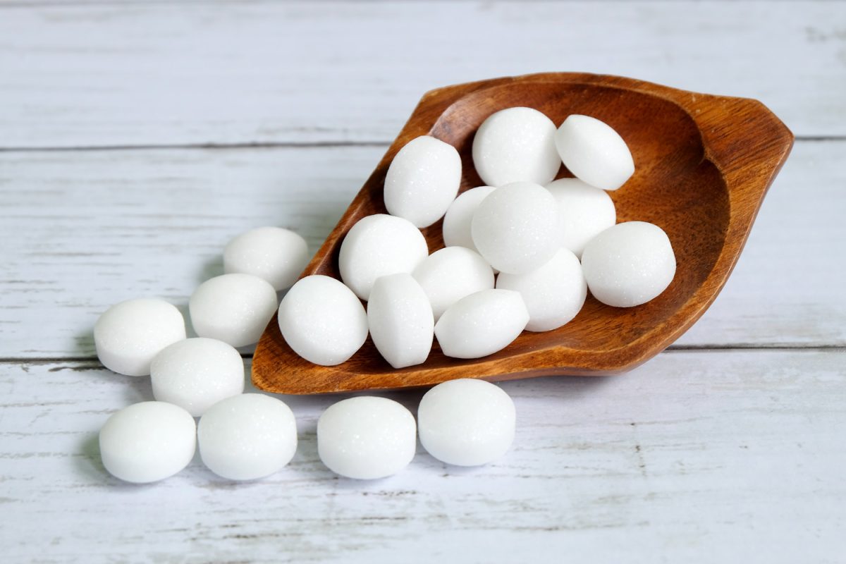 White naphthalene balls on white wooden background
